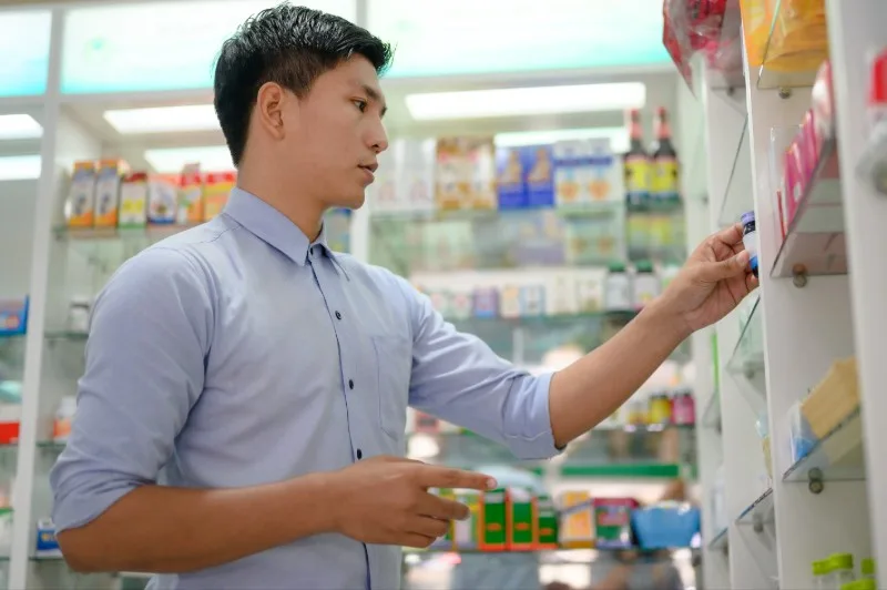 Person stocking pharmacy shelves