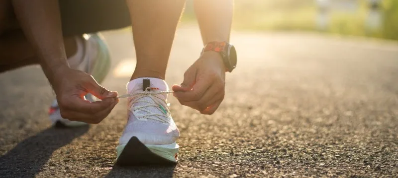 Person tying running shoe laces outdoors