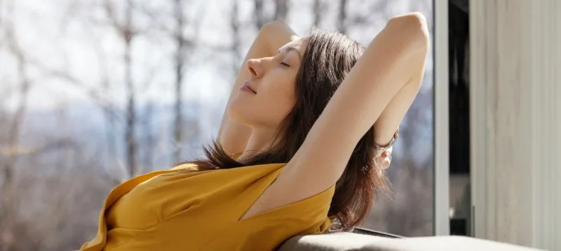 Person reclining with eyes closed on couch