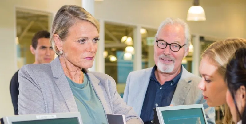 Customers at a reception desk speaking with staff