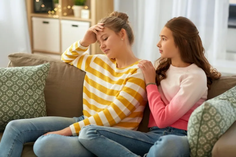 Two teenage girls sitting on a couch