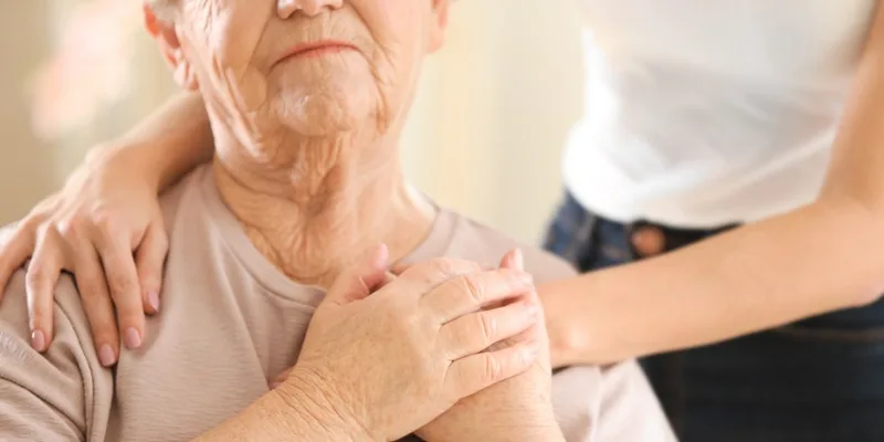 Senior woman being supported by caregiver
