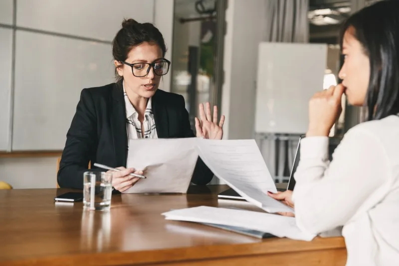 Two women reviewing documents at meeting table