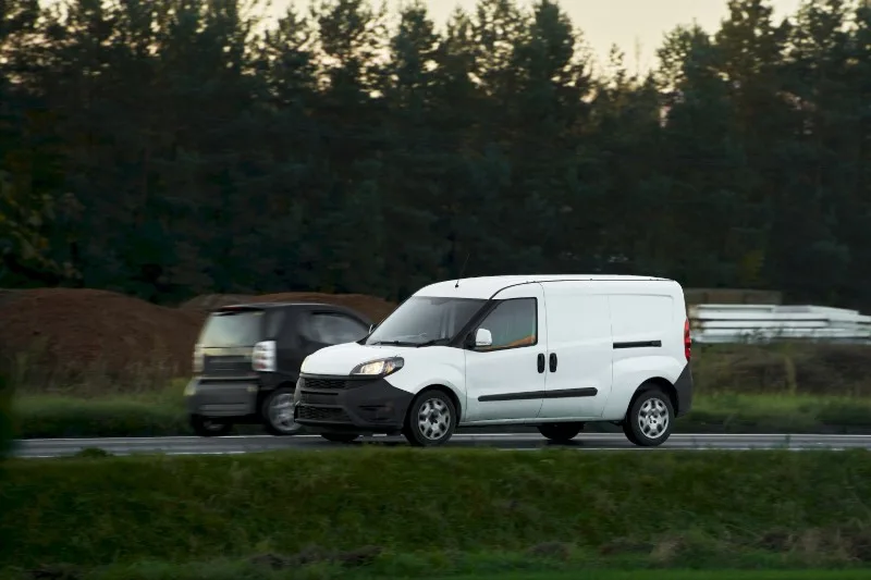 White delivery van driving on road